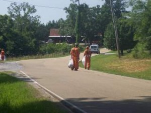 inmates picking up trash on county road